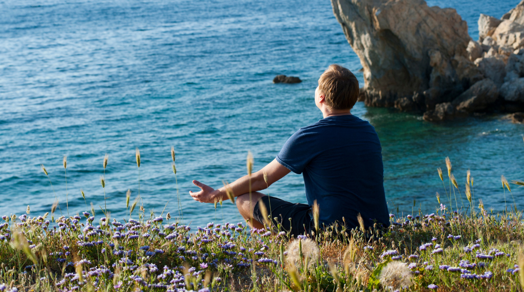 guy-meditating-in-nature-in-front-of-a-sea